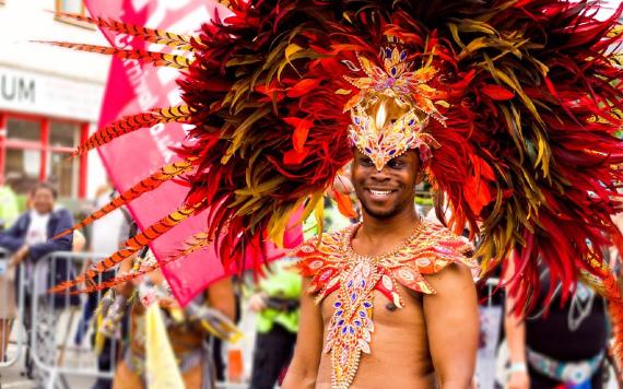 Man with red feather headdress at 2017 Preston Caribbean Carnival.