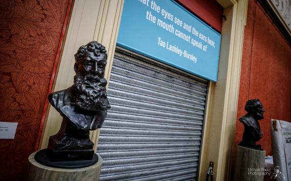 Closed Harris gallery shutters, with black busts still displayed on either side.