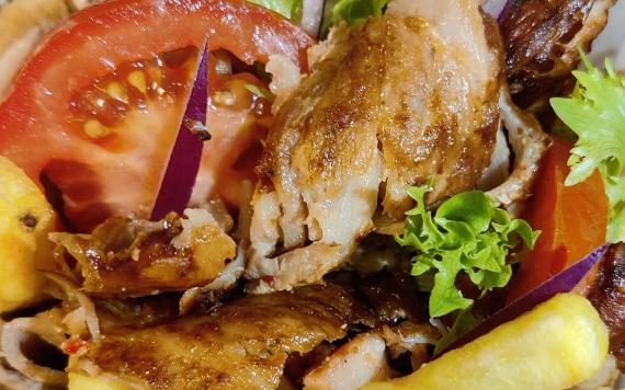 A close up of chicken and salad Gyros prepared by Greekouzina restaurant