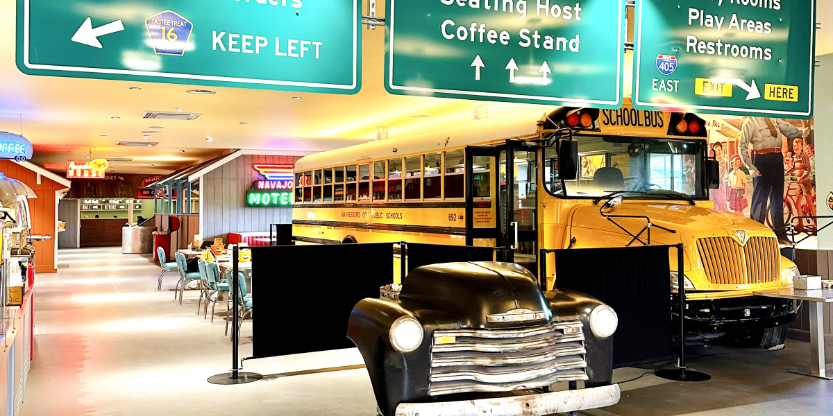 Billy Bob's main entrance interior with a yellow school bus and green American road signs