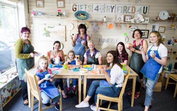 Fired 4 U group of adults and children painting pottery around a table