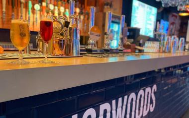 A glass of beer and cider on the bar inside Hopwoods Tap House