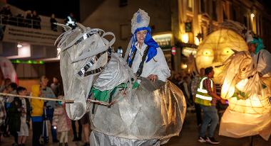 Child on pretend horse in torchlight procession