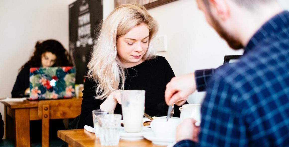 Young couple enjoying coffee and cake at a cafe in Preston