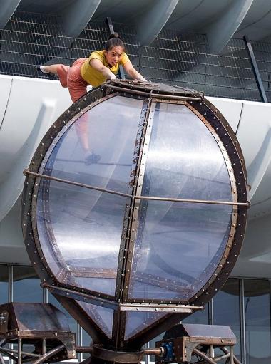 Performer doing acrobatics on giant retro egg timer