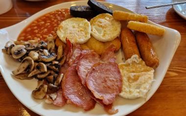 A close up of a large plate with a full English breakfast