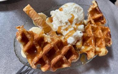 A close up of waffles, ice cream and banana slices from Raffles Coffee House