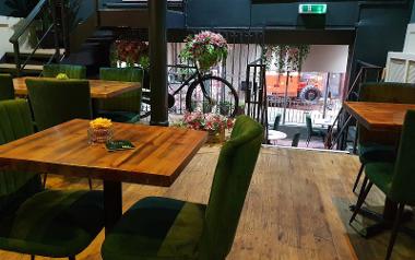 A view of the dining area inside Florianas Restaurant and Bar with a bicycle and flowers decoration