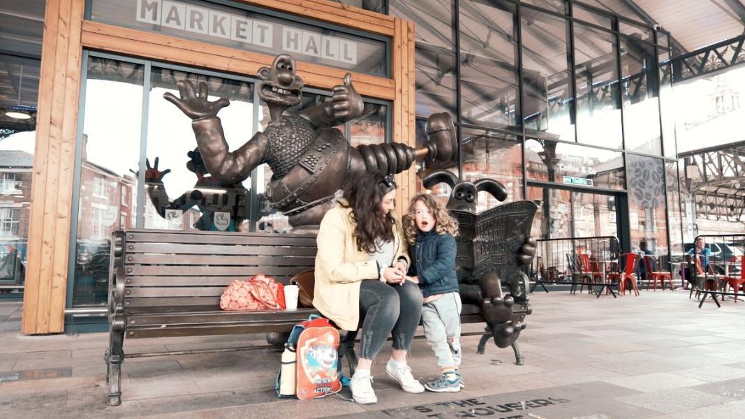 Mother and child sat on Wallace and Gromit bench