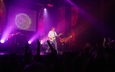 Daniel East and the Shape of You band playing on a stage in front of a crowd