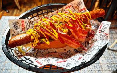 A hot dog with bacon and topped with sauces from Wings and Beer Co.