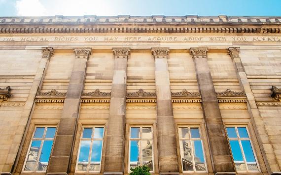 Quote on the side of the Harris building reading "The mental riches you may here acquire abide with you always".