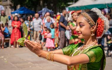 Girl holding sprouting plant in her hands during South Asian Mela performance. Photo by Michael Porter.