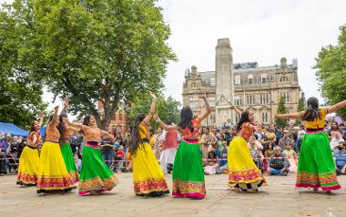 Girls in South Asian dress performing on the Flag Market. Photo by Michael Porter.