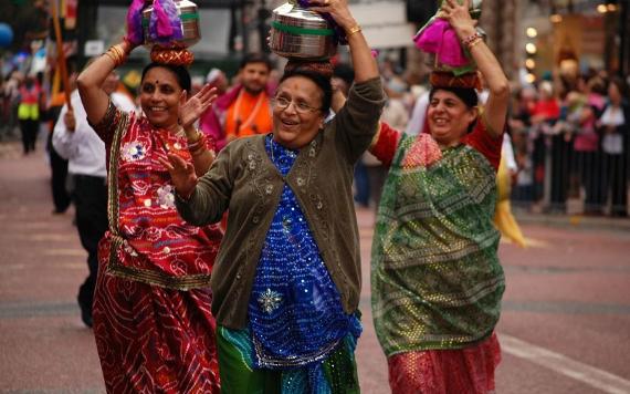 Indian community waving at crowd during 2012 Guild community procession.