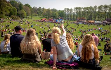 Crowds and funfair at Avenham Park during annual Egg Rolling event.