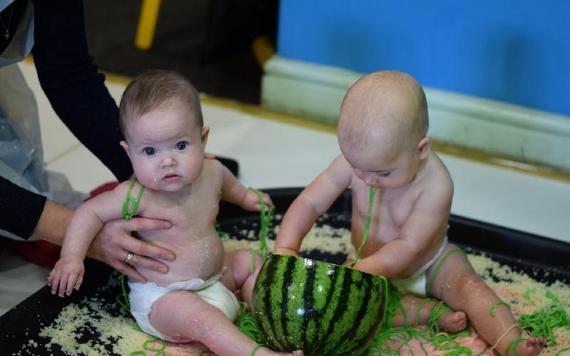 Babies playing with watermelon and items during messy play at Go Create.