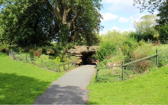 Rock bridge surrounded by flowers and shrubs.