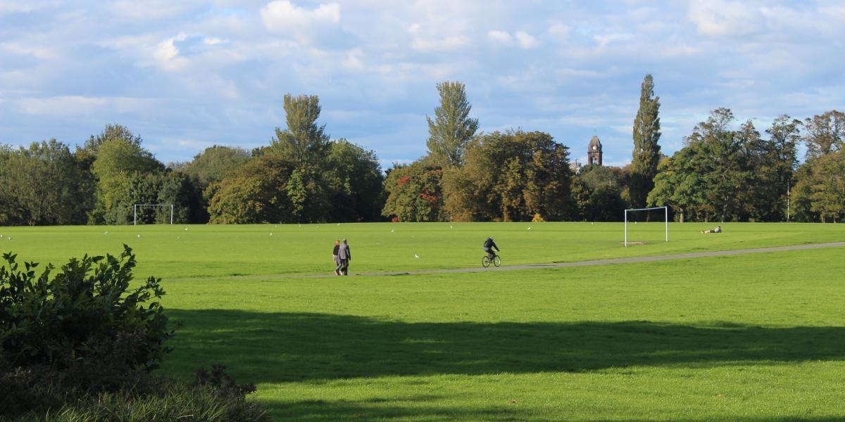 People walking and cycling along pathway in Moor Park, Preston.