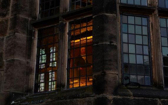 View of painting inside Hoghton Tower, through a window at night.