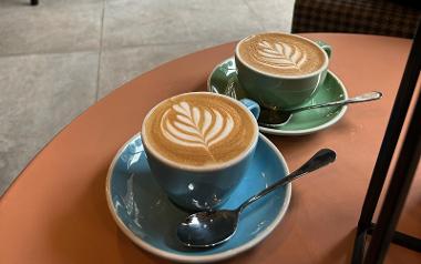 Two coffees with flora pattern in colourful mugs in Brew + Bake café