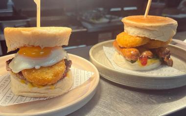 Two breakfast muffins with eggs, hash browns, sausages and sauces in Brew + Bake café