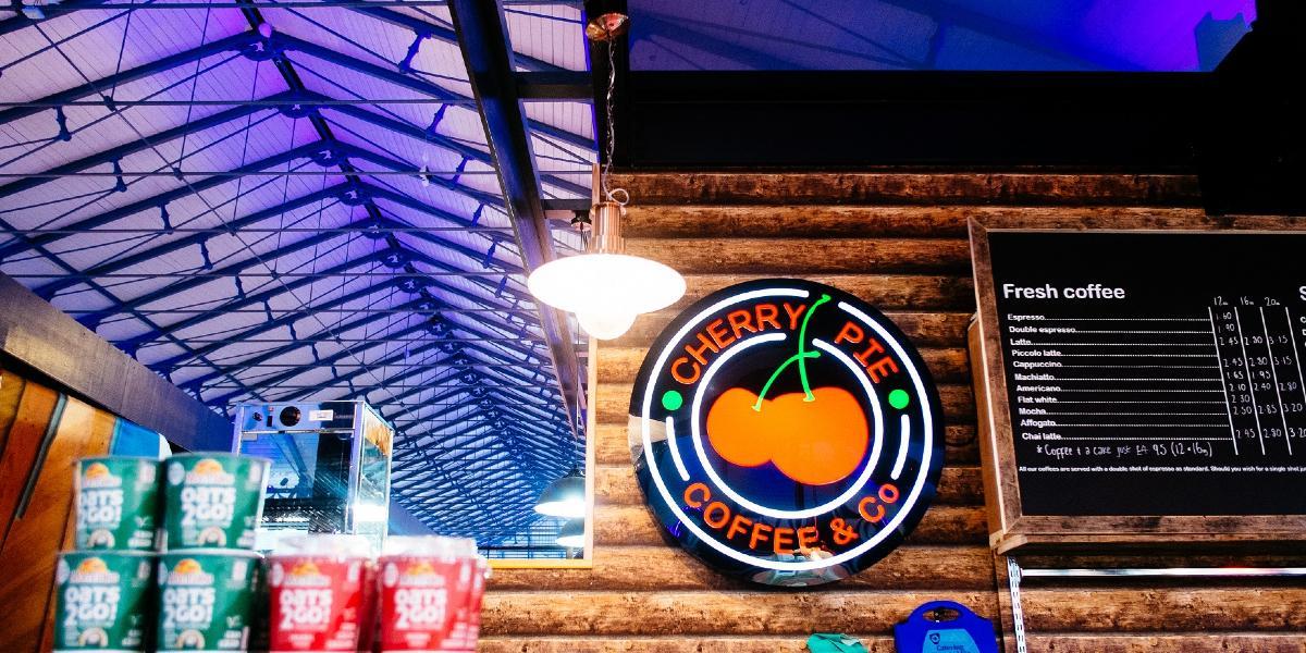 Cherry Pie logo mounter on wooden effect wall behind coffee shop counter.