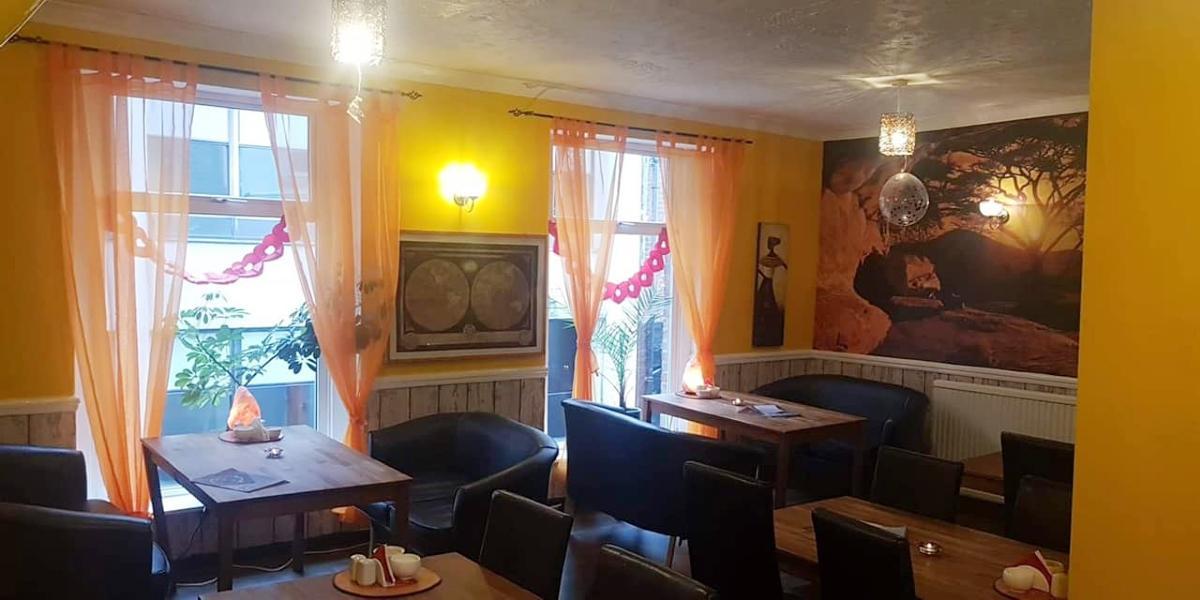 Tea House's upstairs seating area with yellow walls and comfy seating.