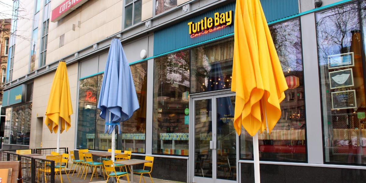 Colourful umbrellas and outdoor seating on Preston Flag Market outside Turtle Bay Restaurant.