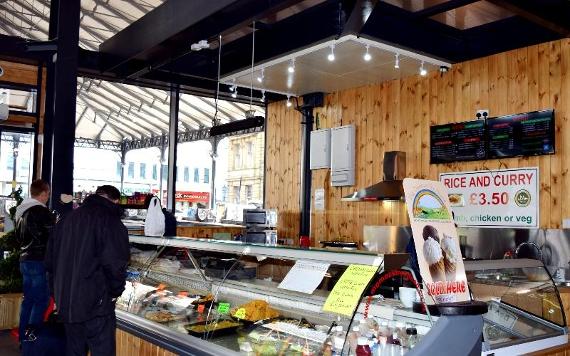 Customers at Momoz Street Food counter inside Preston Markets.