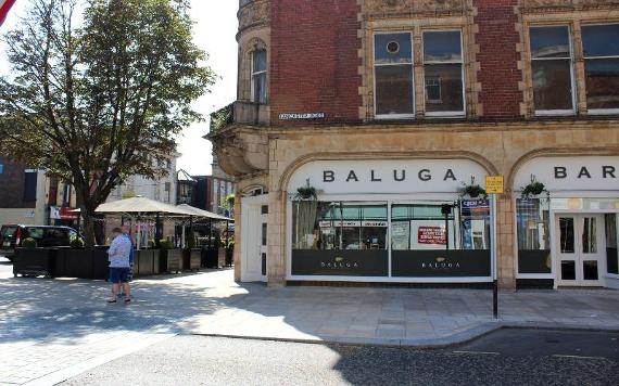 Outside Baluga Bar and Club and its outdoor seating area on sunny day.