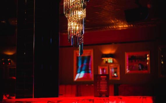 Kuckoo bar area and chandelier all lit up in red.