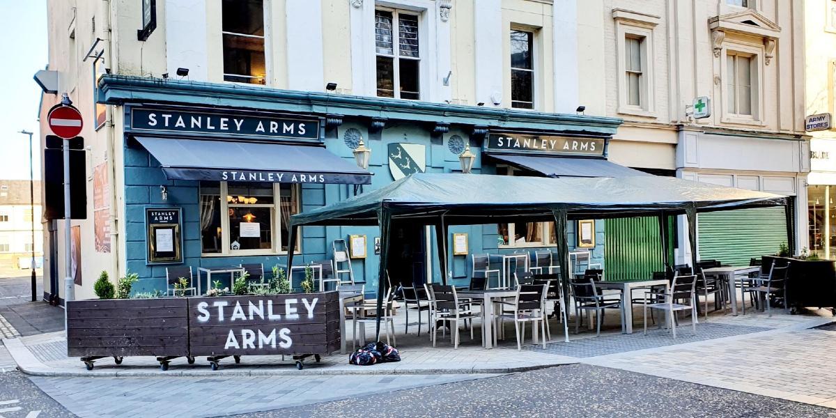 Outside Stanley Arms pub with outdoor seating and weather coverings.