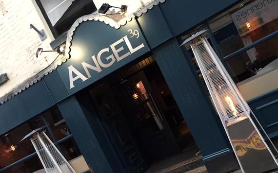 Angel 39 sign and entrance with flame heaters on either side.