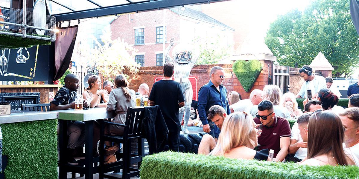 Groups drinking and enjoying sun outside in 1842's Rabbit Hole.