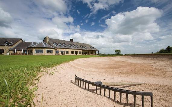 Bunker on golf course with Best Western Garstang hotel in background.