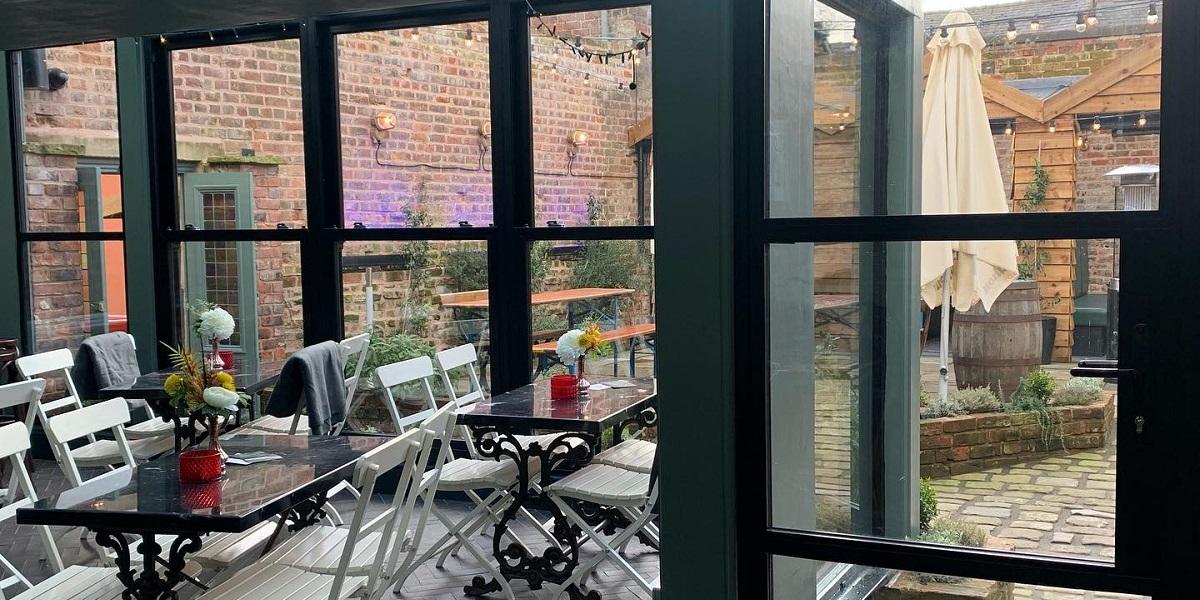 Once was Lost inside seating area and view through glass doors into courtyard.