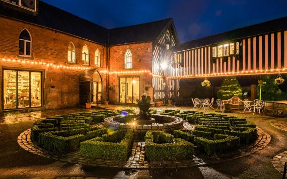 Samlesbury Hall courtyard lit by fairy lights at night.