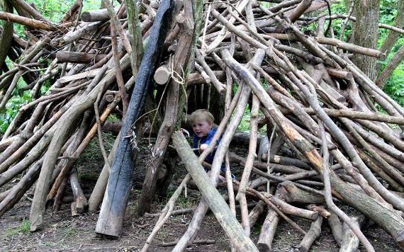 Boy playing inside stick den at Brockholes Nature Reserve.