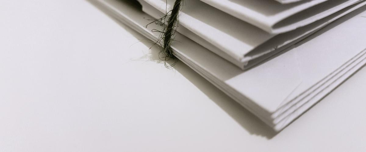 Pile of documents tied together with string.