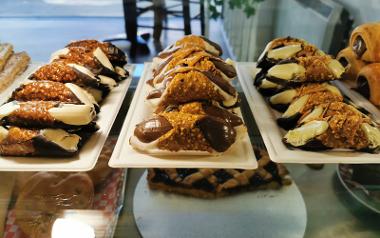 Cannolis and desserts in display counter inside Tuscany Café.