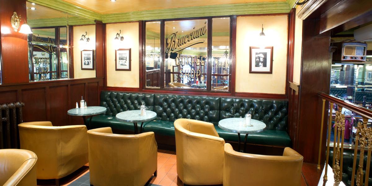 Brucciani's seating area with yellow comfy chairs and vintage decor.